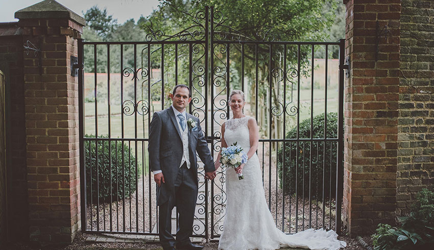 The grounds and iron gates behind a wedding couple at Rowhill Grange
